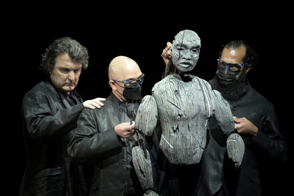 Le baryton Ludovic Tézier à gauche, les marionnettistes et la marionnette d'Amonasro, Aida de Giuseppe Verdi, mise en scène Lotte de Beer, Opéra de Paris, 2021. Photo Vincent Pontet.